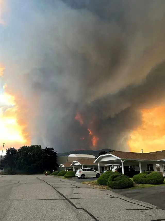 萨默兰市一条居民街道上，鲍德山脉野火产生的浓烟升腾而起。