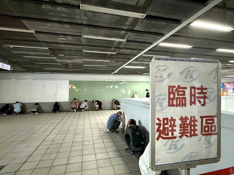 高雄市今天上午10時舉行2026城鎮韌性防空演習，軍方、捷運生態園區站旅客蹲牆角抱頭避難情形。記者石秀華／攝影
