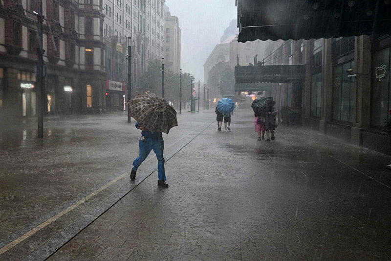 上海市氣象台提醒市民強降雨可能引發城市積澇,圖為10日上午上海和平飯店外大雨如注的景象。法新社