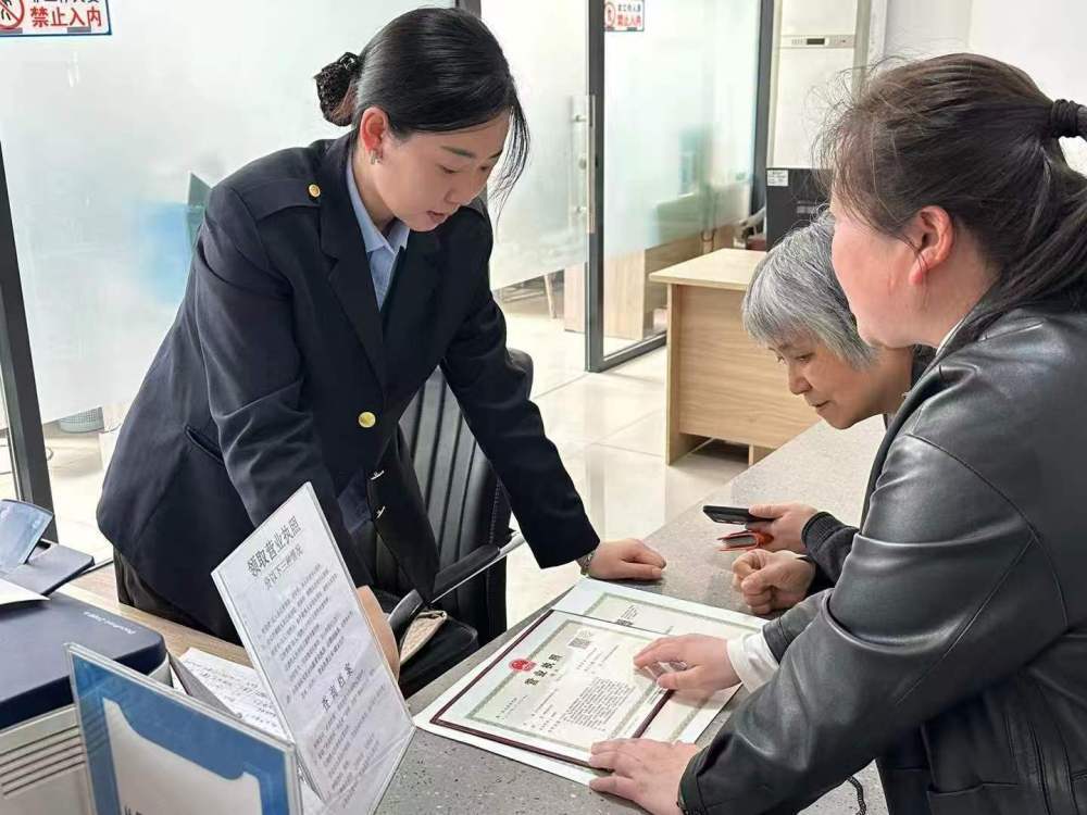 锦州市古塔区政务服务中心窗口工作人员为群众讲解营业执照领取及相关后续办理流程,协助完成执照发放环节(2026年3月11日摄)。(受访单位供图)