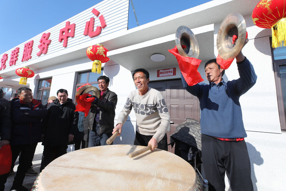 2025年1月28日，辽宁省葫芦岛市绥中县明水满族乡祝家沟村村民在重建新房的村党群服务中心前鸣锣击鼓。新华社发（田嘉摄）