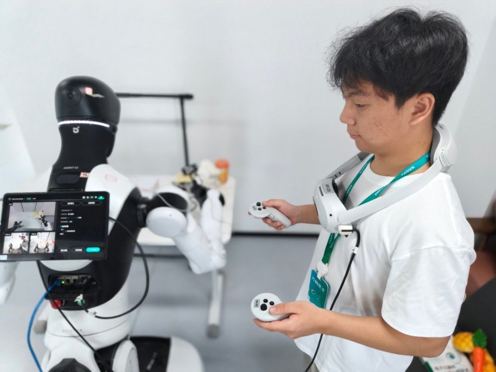 7月30日，浙江清华柔性电子技术研究院具身智能实训场里，作为数据采集员，朱思凯身上要佩戴专业的VR眼镜，手持机械爪来同步控制机器人的上肢动作。中青报·中青网记者 宁迪/摄