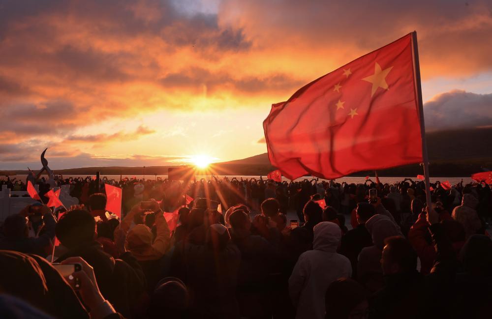 10月1日,人们在我国陆地最东端的黑龙江省抚远市迎接朝阳。新华社发(李拥军 摄)
