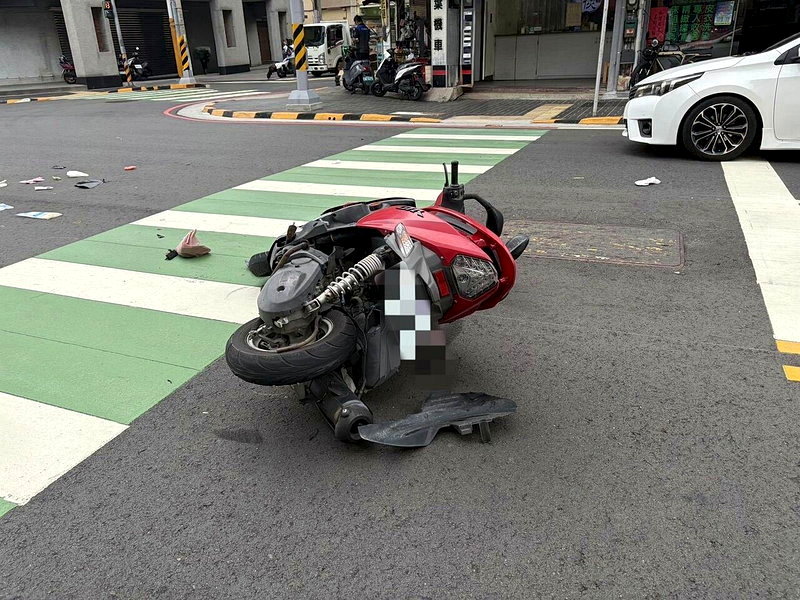 70歲何男騎機車行經太平區中興路、新平路口時闖紅燈，遭綠燈直行的轎車撞飛重傷，現場機車倒地，零件四散。圖／讀者提供