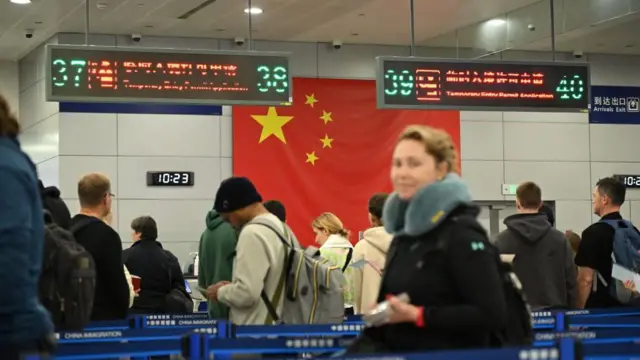 上海浦东机场,中外游客在边检大厅等候办理入境手续。