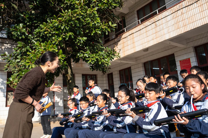 2026年1月13日，在湖南益阳南县三仙湖镇中心小学，音乐老师（左一）指导学生练习口风琴。新华社记者 陈思汗 摄