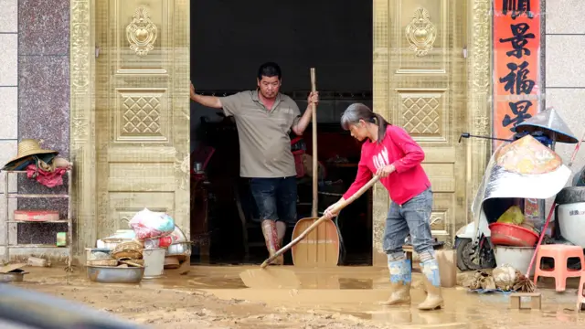 中国广西南宁横州市，村民在洪水退却后清理泥泞，穿着水靴的中年男子一脸无奈（7/7/2026）