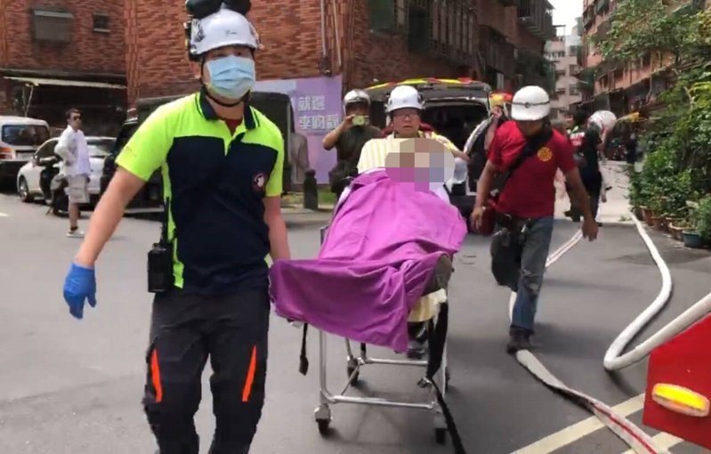 基隆市今天發生民宅火警，位在公寓的2樓竄出火煙，兩人受困屋內。消防員布設水線滅火，及時救出兩人送醫，起火原因由消防局調查中。記者邱瑞杰／翻攝